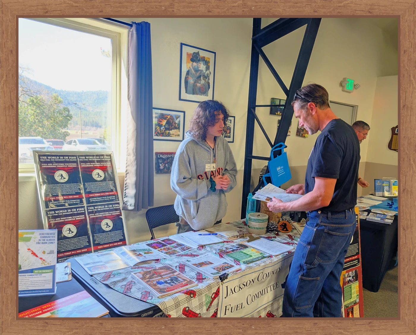 An organizer signs up a new JCFC member at an information table.